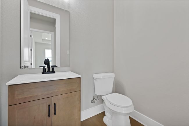 Half bathroom featuring vanity, wood finished floors, and a textured wall | Image 15