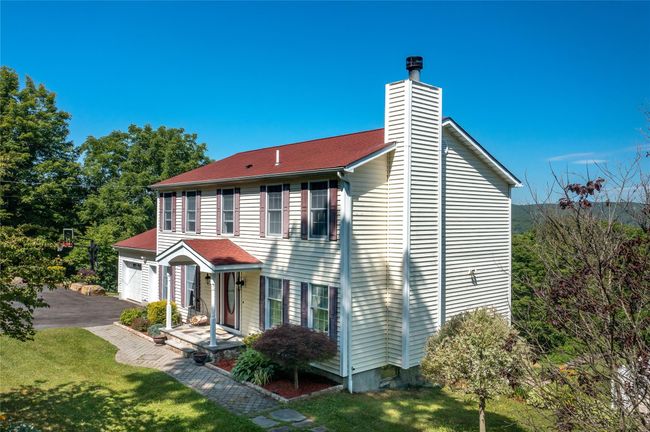 View of front facade featuring a chimney, a garage, a front lawn, asphalt driveway, and a porch | Image 4