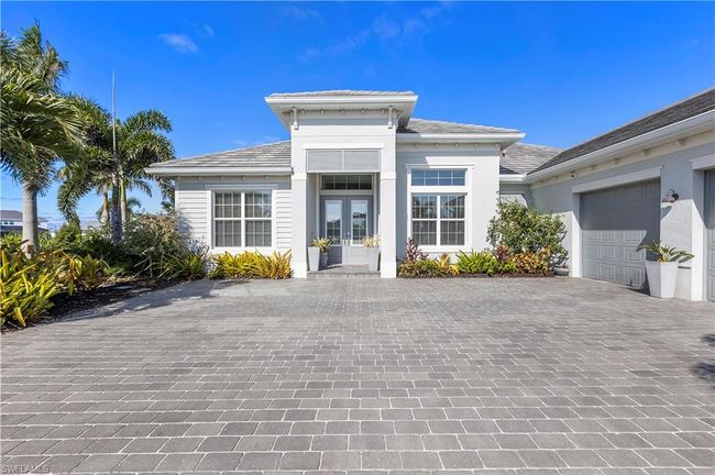 View of front of house with french doors, decorative driveway, an attached garage, and stucco siding | Image 19