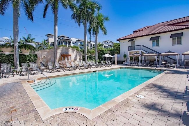 View of community pool with a patio area, lounge chairs and cabanas | Image 30