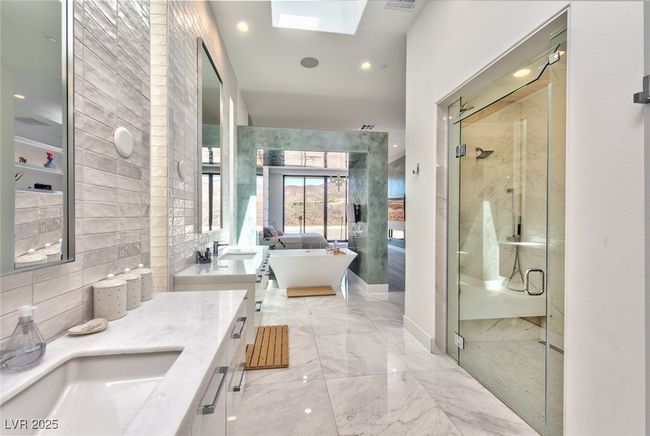 Bathroom with a sink, double vanity, a freestanding tub, a shower stall, and a skylight | Image 15