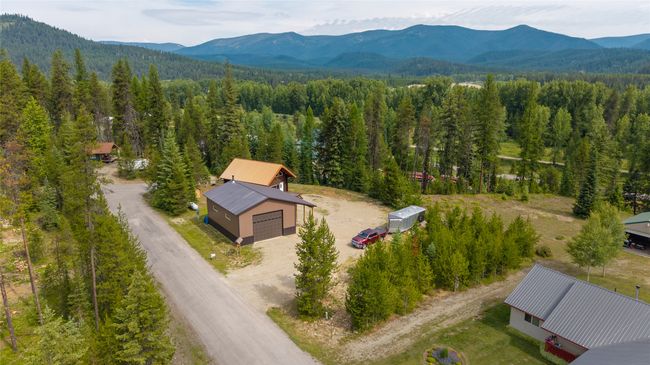 Aerial view of property and surrounding area with mountains and a heavily wooded area | Image 59