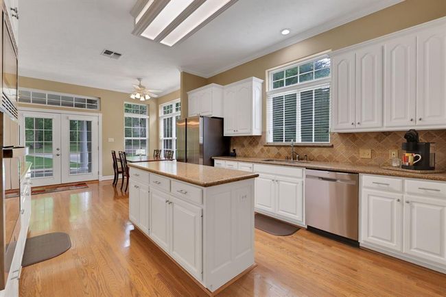 Beautiful tile backsplash and long island create a sophisticated atmosphere in the kitchen | Image 16