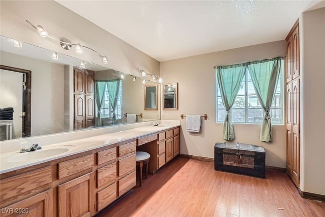Bathroom featuring double vanity, a sink, baseboards, and wood finished floors | Image 20