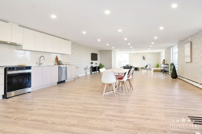Kitchen featuring stainless steel dishwasher, wallpapered walls, open floor plan, electric range oven, and white cabinetry | Image 17