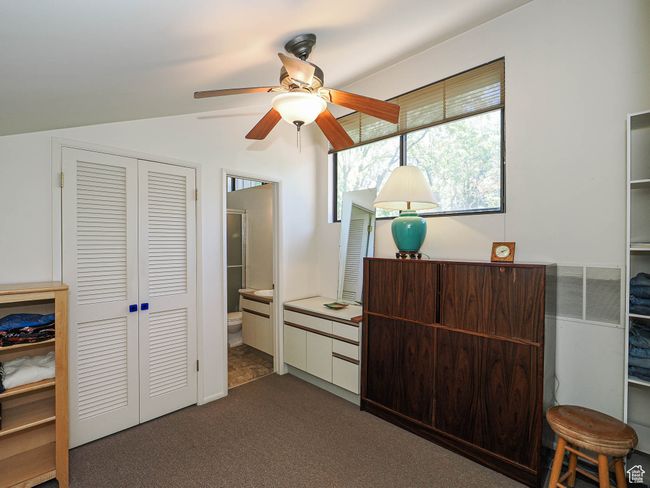 Carpeted bedroom featuring a closet, vaulted ceiling, and ensuite bath | Image 38