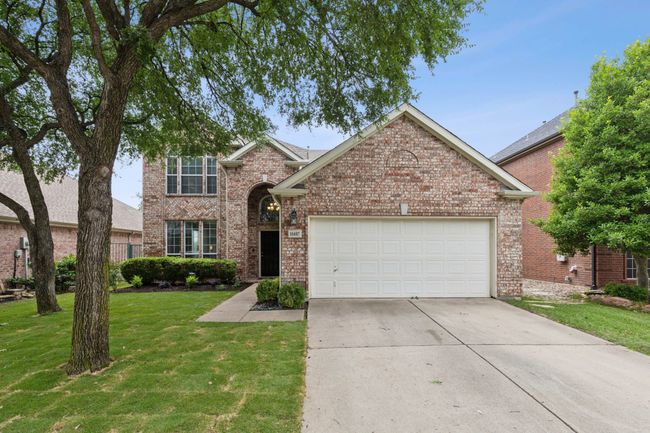 Traditional home with concrete driveway, an attached garage, brick siding, and a shingled roof | Image 37