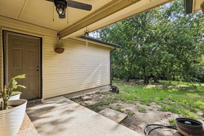 View of exterior entry featuring a ceiling fan and a patio | Image 22