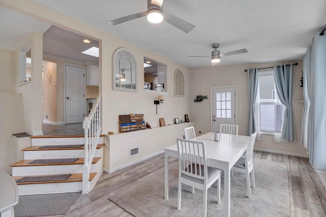 Dining room featuring stairway, visible vents, a ceiling fan, light wood-type flooring, and baseboards | Image 23