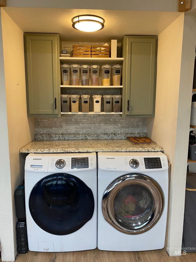 Laundry room with washer and clothes dryer, cabinet space, and light wood-style flooring | Image 14