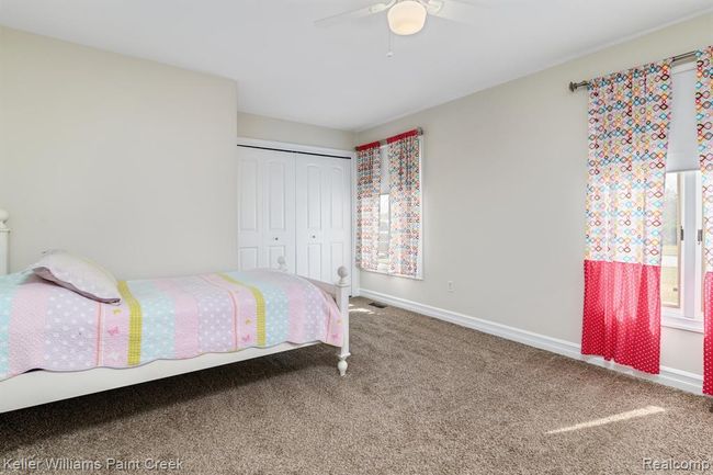 Additional bedroom features fresh paint, soft carpet, and ample closet storage. | Image 9