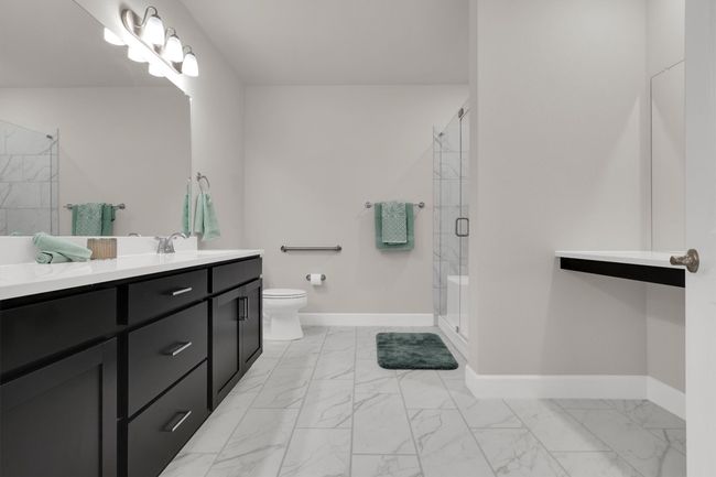 Master Bathroom -Full bathroom featuring marble finish floors, double sinks, a walk-in shower stall with bench, vanity with mirror, toilet, and baseboards | Image 22