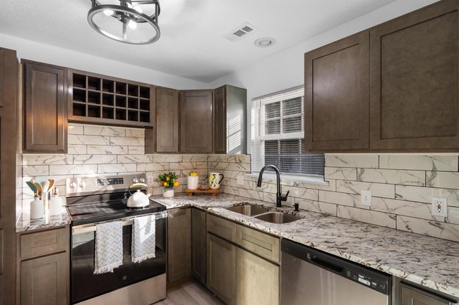 Kitchen with appliances with stainless steel finishes, a sink, plenty of natural light, and tasteful backsplash | Image 7