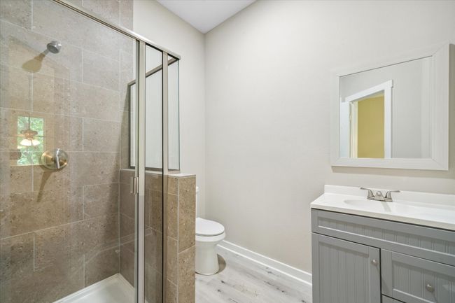 Full bathroom featuring vanity, a shower stall, wood finished floors, toilet, and baseboards | Image 33