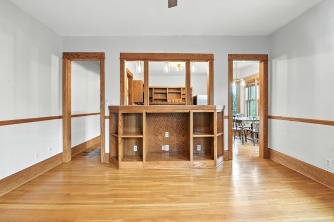 Gorgeous original wood built-in with open shelving and pass-through windows connects the living room to the kitchen and dining area, enhancing the open feel. | Image 11