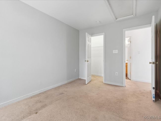 Unfurnished bedroom with light carpet, a walk in closet, attic access, and a closet | Image 22