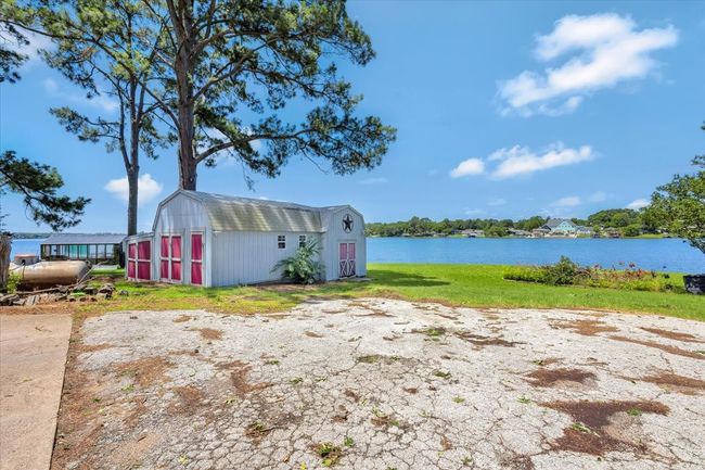 View of green lawn with a water view and a storage unit | Image 14