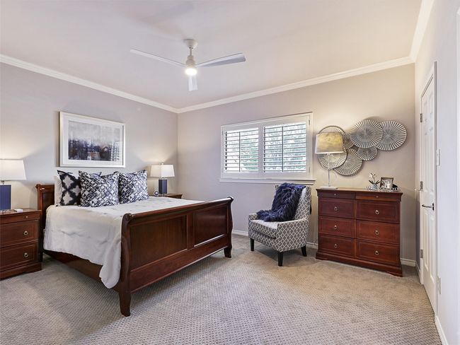 Bedroom with ornamental molding, light carpet, and ceiling fan | Image 25
