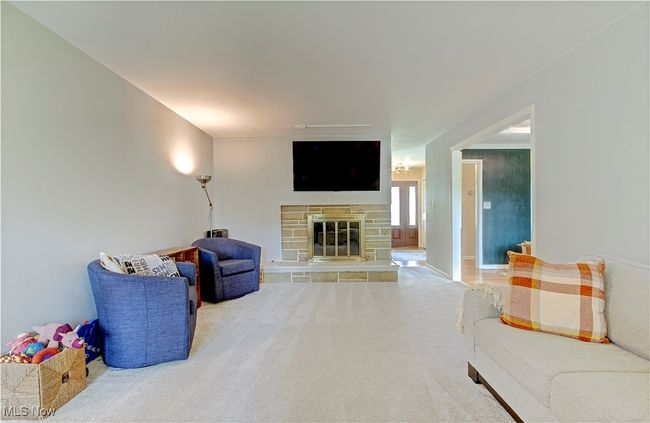 Unfurnished living room featuring carpet flooring and a stone fireplace | Image 11