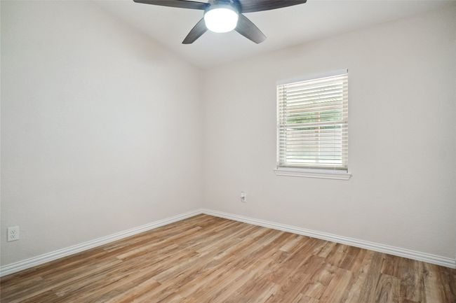 Bedroom with light wood finished floors, healthy amount of natural light and a ceiling fan with remote | Image 16