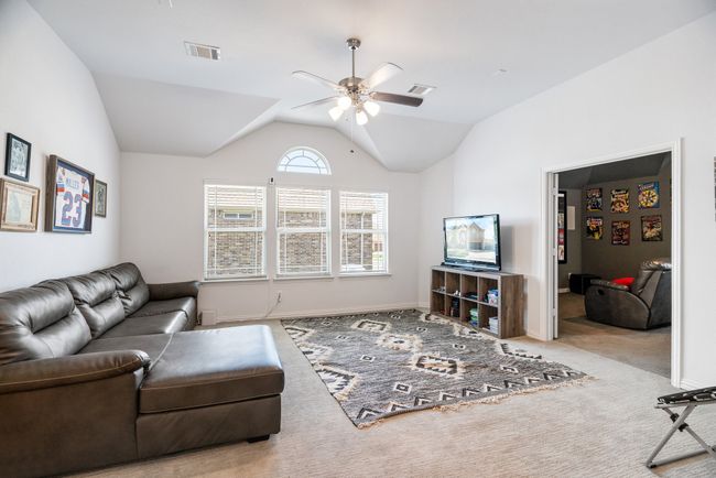 Carpeted living area with a ceiling fan and lofted ceiling | Image 25