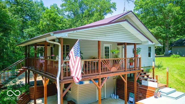 view of front of home with stairs, a front yard, a patio area, and a wooden deck | Image 6
