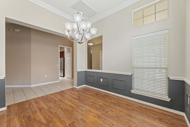 Unfurnished dining area with crown molding, a chandelier, and wood finished floors | Image 12
