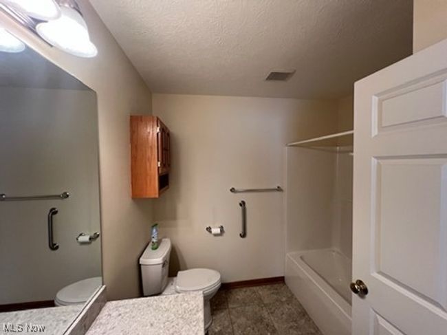 Full bath with vanity, a textured ceiling, and bathtub / shower combination | Image 22
