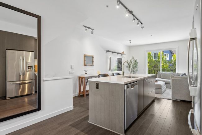 Kitchen featuring stainless steel appliances, a sink, open floor plan, modern cabinets, and dark wood finished floors | Image 15