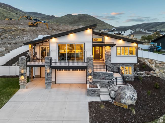 Contemporary home with a garage, stone siding, a mountain view, concrete driveway, and stairs | Image 69