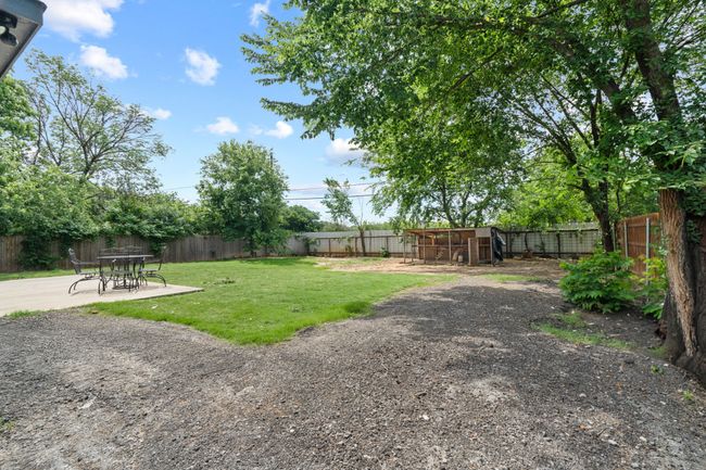 Fenced backyard with a patio area | Image 38
