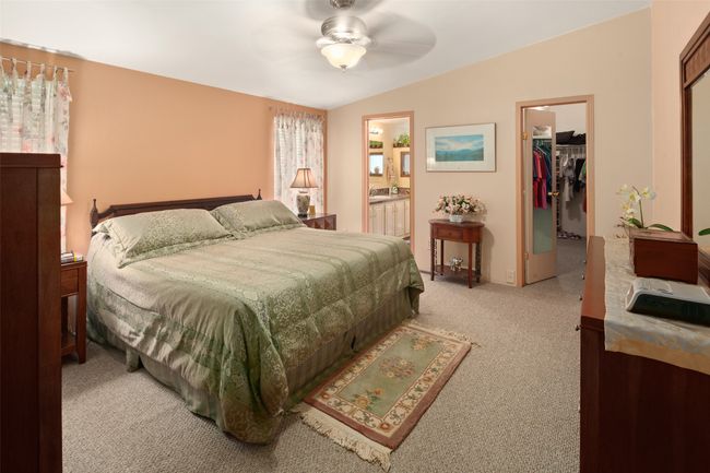 Bedroom featuring light colored carpet, a walk-in closet & ensuite bath | Image 20