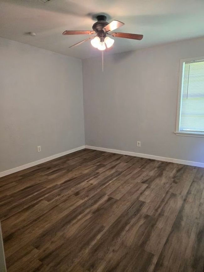 Empty room with ceiling fan and dark wood finished floors | Image 24