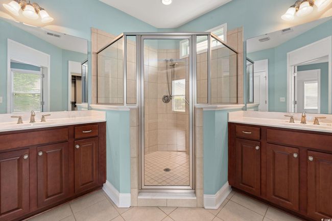 Full bathroom featuring visible vents, a shower stall, tile patterned flooring, and vanity | Image 21