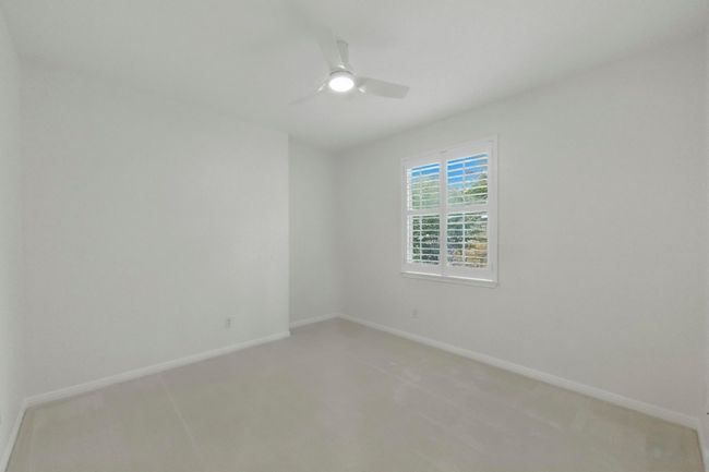 Secondary bedroom with natural light, simple shutters, new carpet and fan. | Image 28