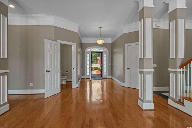 Foyer entrance with light wood-style flooring, stairway, decorative columns, and crown molding | Image 7