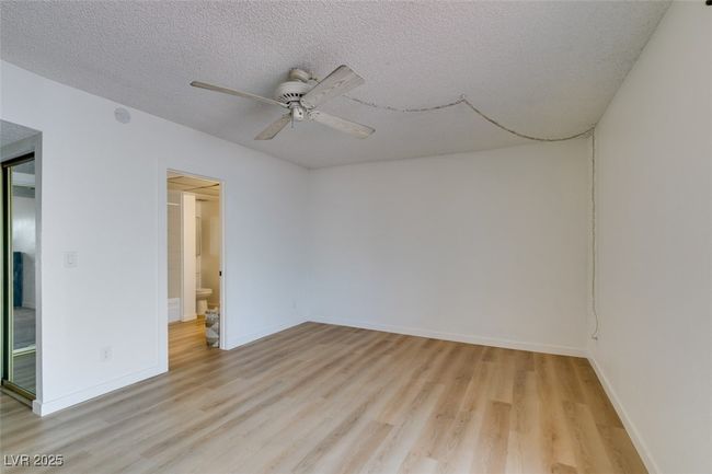 Spare room featuring light wood-style flooring, ceiling fan, a textured ceiling, and a smoke detector | Image 32