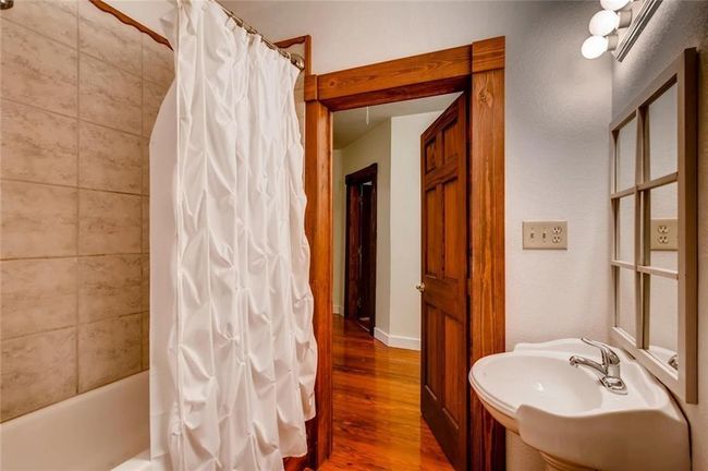 Bathroom with wood finished floors and shower / bath combination with curtain | Image 13