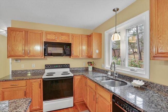 Granite counters, hardwood floors, island with seating for four | Image 7