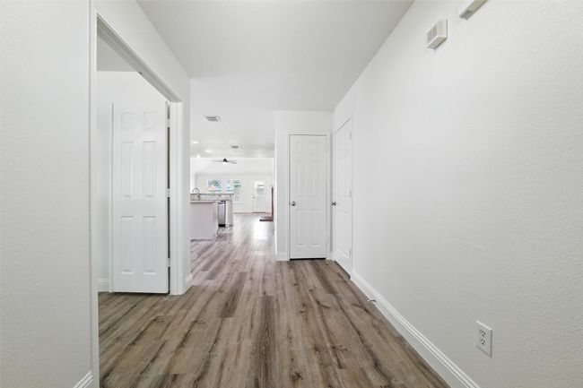Hallway featuring wood finished floors and baseboards | Image 4