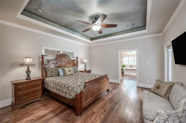 Discover a luxurious primary bedroom retreat featuring a French door to the "Winter Patio, " elegant glazed ceiling, detailed molding, and a stylish en-suite bath. | Image 14