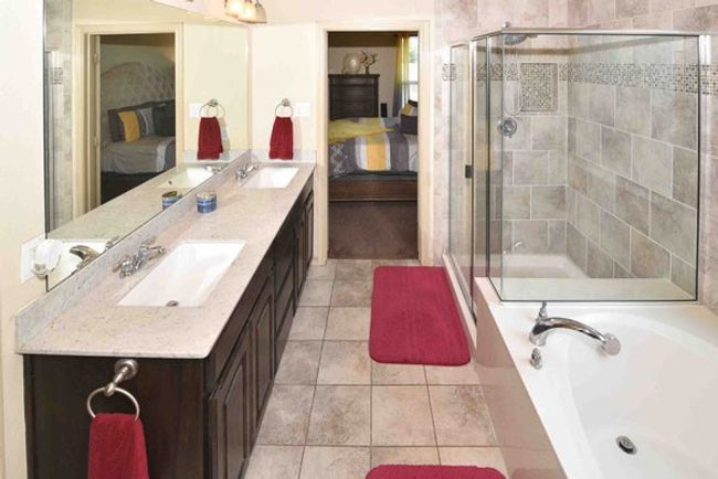 Ensuite bathroom featuring a garden tub, a stall shower, double vanity, and tile patterned floors | Image 20