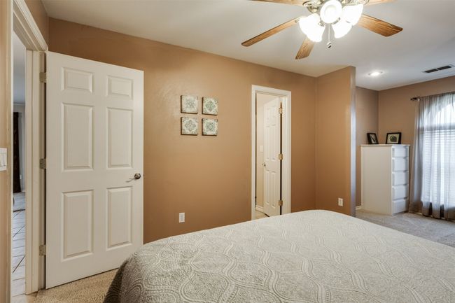 Bedroom featuring light carpet, visible vents, and ceiling fan | Image 14