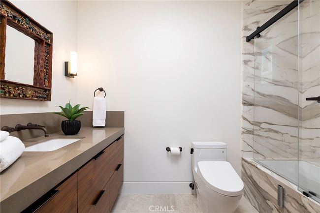 Full secondary bath with stone counters and all-slab stone shower and Toto Washlet toilet. | Image 18