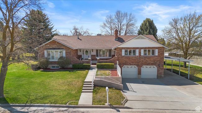 Single story home with concrete driveway, a front lawn, stairs, brick siding, and a garage | Image 46