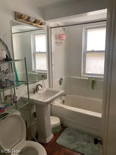 Bathroom with a healthy amount of sunlight, toilet, and shower / tub combination | Image 3