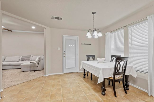 Dining area with recessed lighting, visible vents, light tile patterned flooring, a chandelier, and baseboards | Image 12
