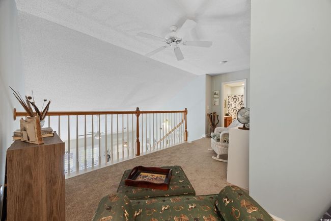 Sitting room with lofted ceiling, carpet flooring, ceiling fan, and a textured ceiling | Image 30