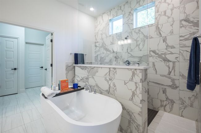 The primary bathroom is absolutely gorgeous and contains a deep soaking tub that is adjacent to the beautifully built walk-in shower. | Image 19