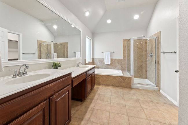 Full bathroom featuring a stall shower, double vanity, a garden tub, vaulted ceiling, and tile patterned floors | Image 26